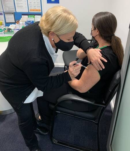 Judy Plunkett from Plunkett's TerryWhite Chemmart Port Macquarie delivers a COVID vaccine to Candice Williams. Photo: Plunkett's TerryWhite Chemmart Port Macquarie