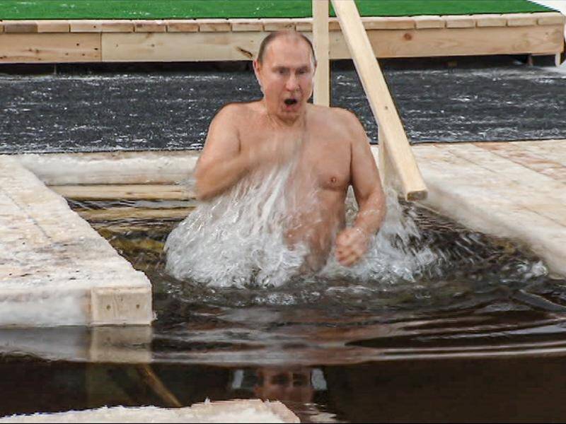 President Vladimir Putin has crossed himself while bathing in icy water in Epiphany celebrations.