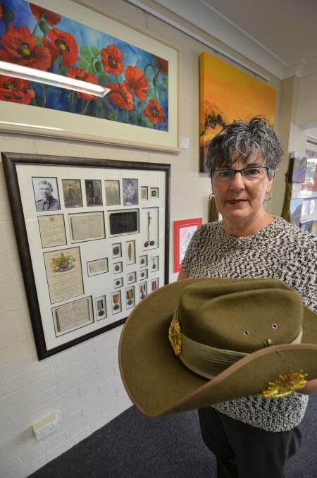 Vast collection: Denise Davis stands in front of the Sergeant H.M. Adams  
display, which is part of the Anzac Day art, photographic and memorabillia exhibition at Masterpiece Framing Gallery.  
Pic: NIGEL MCNEIL
