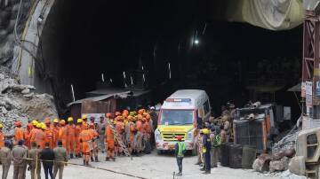 Ambulances have lined up at the mouth of a tunnel to transport trapped workers to a hospital. (AP PHOTO)
