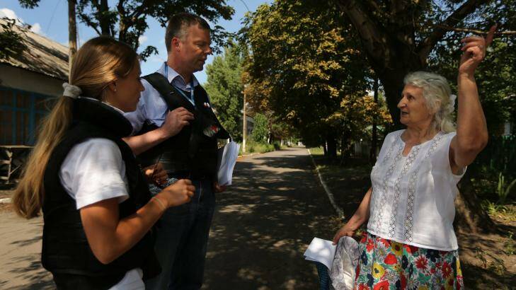Deputy head of the OSCE mission Alexander Hug (second from right) talks with retired kindergarten teacher Era Pavlovna, 76, (right) after handing her a pamphlet on how to return debris of MH17 crash, in Rassypnoe. Photo: Kate Geraghty