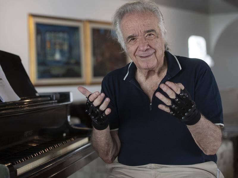 Brazilian pianist Joao Carlos Martins uses bionic gloves to play despite damage to his hands.