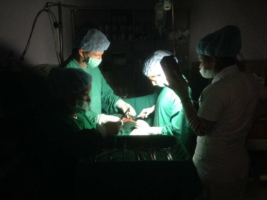 Health focus: Australians for Women's Health founder and specialist gynaecologist obstetrician Dr Ray Hodgson performs a caesarean by torchlight last week in remote Nepal.