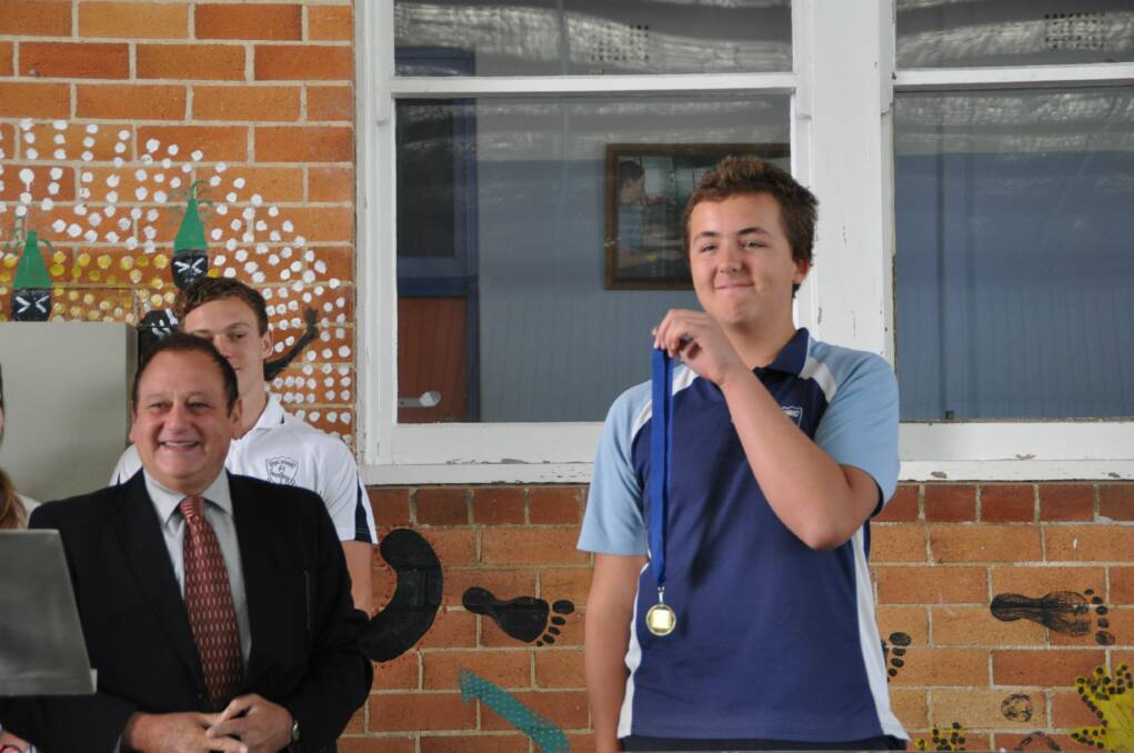Historic achievement: Owen McKittrick is presented with his NSW History Bee medal by Wauchope High School principal Glen Sawle at the school assembly on Monday