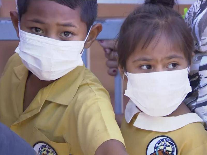 Masked children wait to get vaccinated at a health clinic in Apia, Samoa.