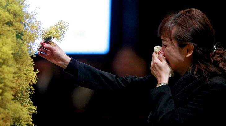 Time for faith: A woman places a sprig of wattle in the cathedral's wreath in honour of the fallen. Photo: Eddie Jim