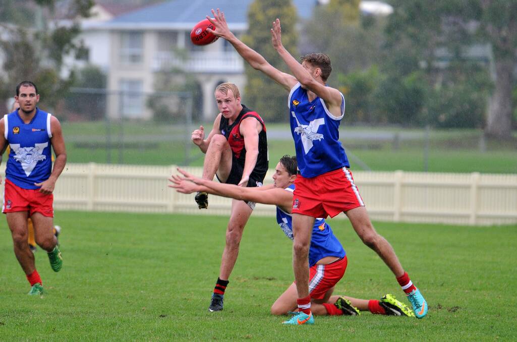 Kicking forward: Kane Hedges in action for the Camden Haven Bombers in the wet at Laurieton Oval on Saturday.  
Pic: MATT ATTARD