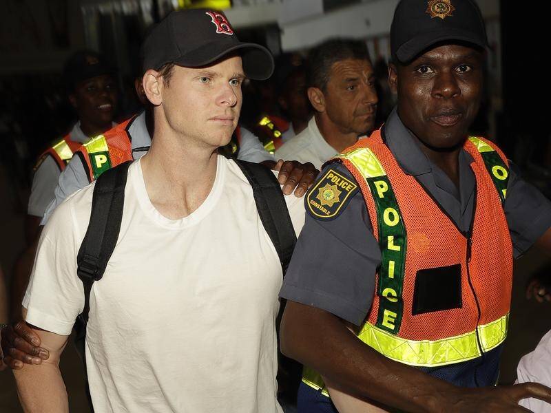 South African police escort Steve Smith to an airport departure area in Johannesburg.