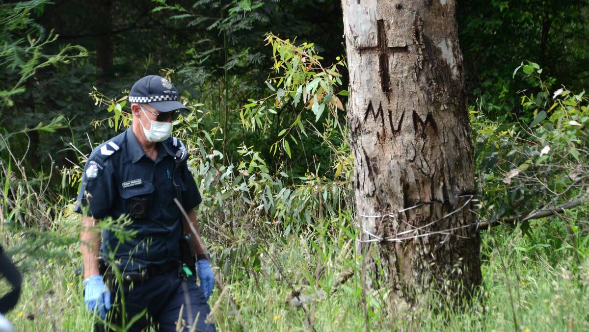 Police scour the area near a tribute carved for Ruth Ridley in a tree on Wednesday. Pictures: Blair Thomson 