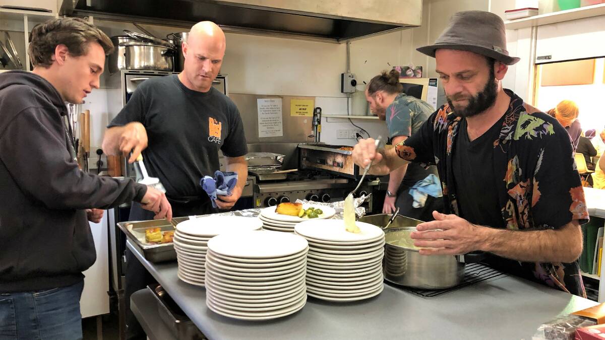 Happy to help: Volunteers Kaleb Crowhurst, chef Nick Philip, Joel Murdoch and Chip Christian cooking in the background.