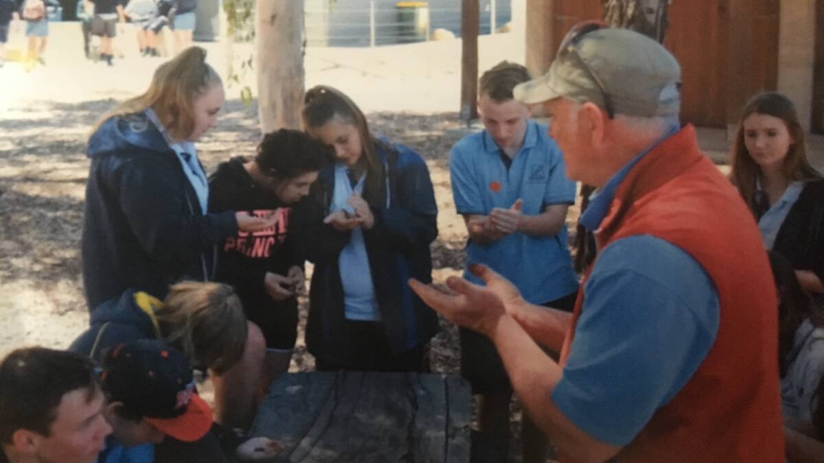 Dr John Rafferty during science week last year, teaching a class and working with earthworms.