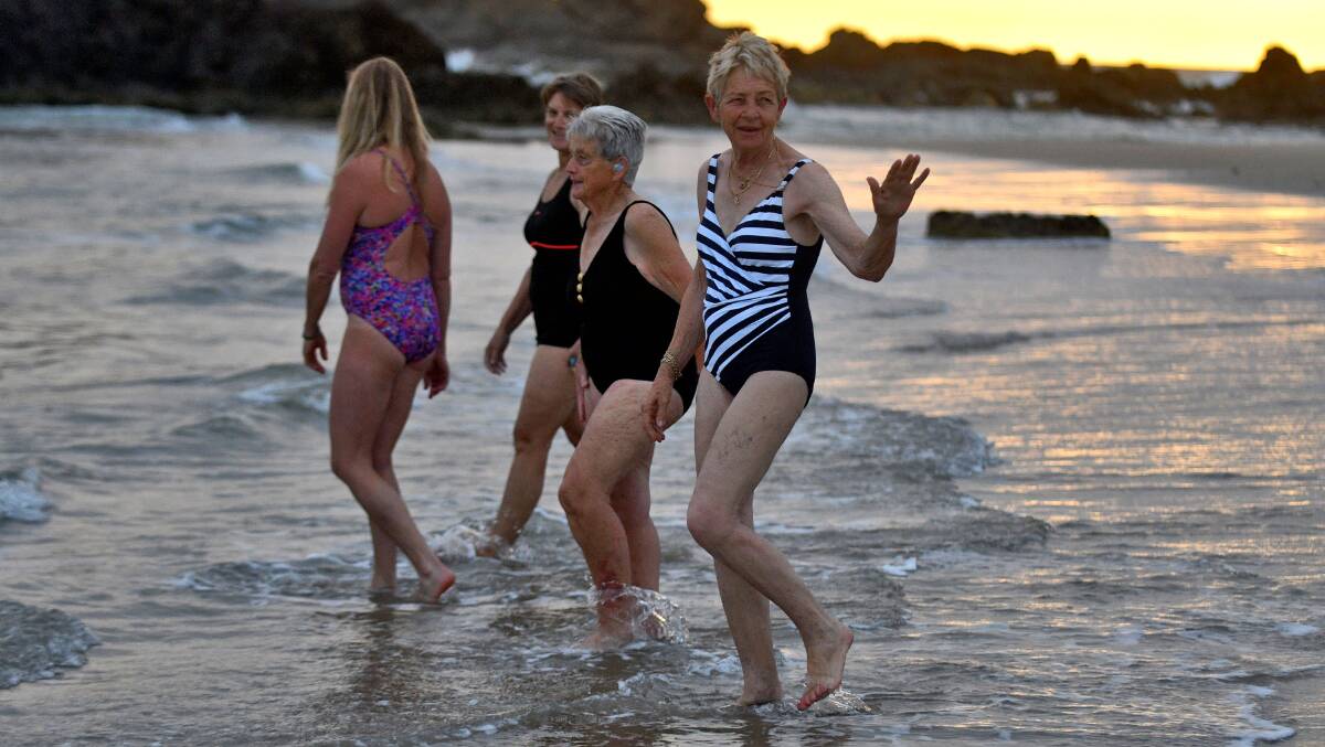 Friendship: Julie Constable waves to members of the group as her and other Sunrise Swimmers enter Town Beach. Photo: Matt Attard