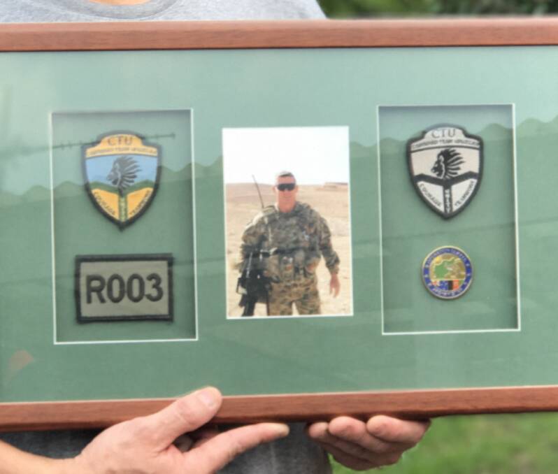 Constant reminder: Paul's framed collection of his personal badges and soldier number. He does not shy away from his role in the army as a gunslinger.