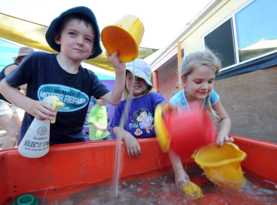Fun with water: Abel Jones, Isabelle Palmer and Taylee Miller from Lighthouse Childcare find a game to help cool off yesterday. Pic: PETER GLEESON