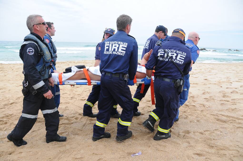 Paramedics and rescue service workers attend to the shark victim earlier today.
