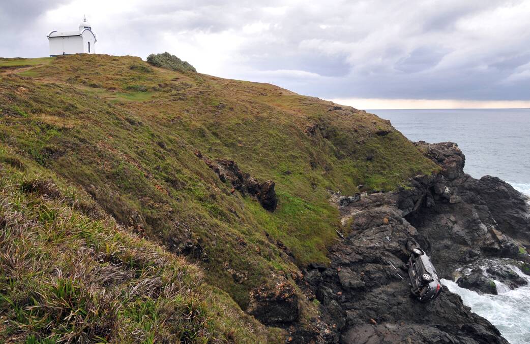 The car lies at the bottom of the cliff near Tacking Point Lighthouse.