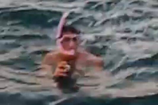 The man trying to get underwater photos of the shark. Pic: Screenshot from Chris Wakeling's video.