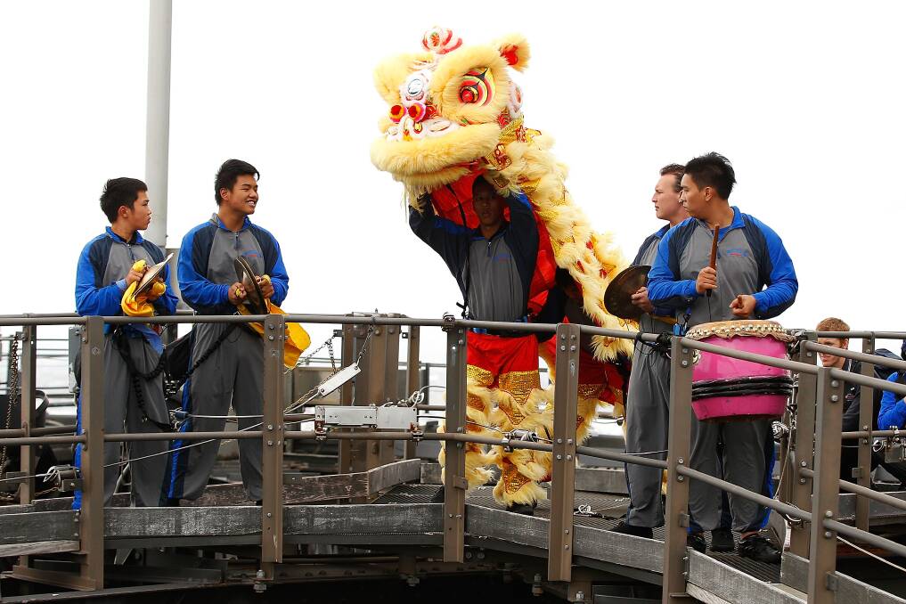 People perform the traditional Chinese Lion Dance atop of Sydney Harbour Bridge in Sydney, Australia. Photo by Brendon Thorne/Getty Images